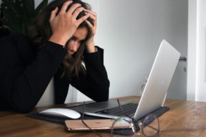 frustrated professional woman in front of a laptop